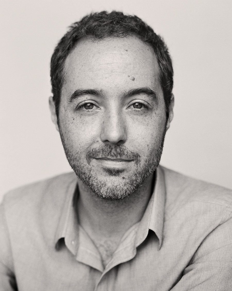 Black and white portrait of Travis LeRoy Southworth, looking directly at the camera in an open-collared shirt